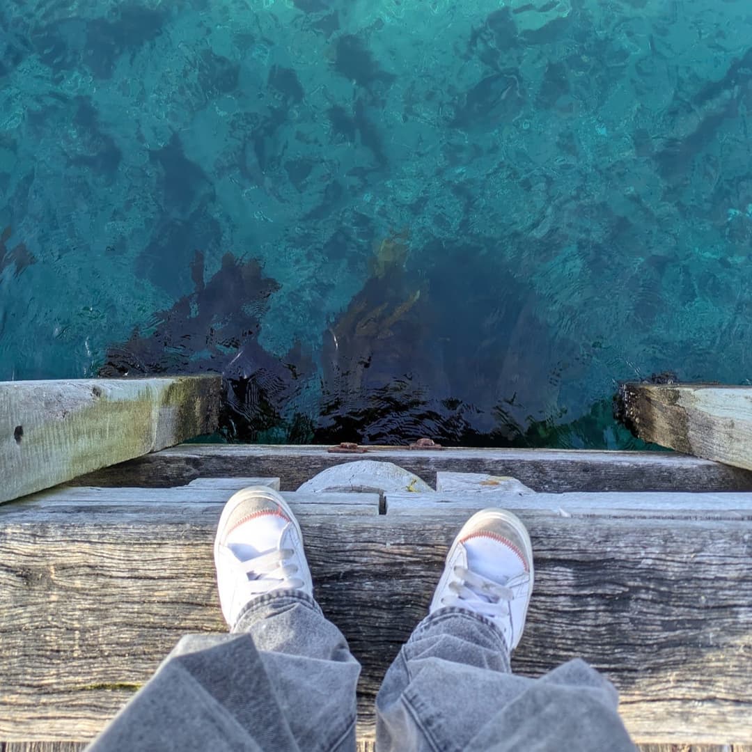 Standing on a jetty looking down into clear Victorian coastal water